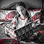 Ellie Mae is registered to the contest to win money with this photo: child, girl, reading, book, bed, bedding, plaid, striped_socks, holiday, christmas, decor, red, white, black_and_white, portrait, indoors, cozy, young, relaxed, furniture