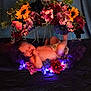 newborn, baby, sleeping, flower_wreath, floral_arrangement, purple_lights, diaper, peaceful, infant, cute, decorative, soft_lighting, dark_background, colorful_flowers, portrait, resting, tender, adorable, celebration, cozy