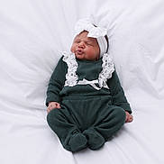 Ava participe au concours pour gagner de l'argent avec cette photo : baby, infant, puckered_face, white_bow, headband, green_outfit, lace, cozy_clothing, sitting, soft_blanket, cute_expression, newborn, child, portrait, indoors, adorable, sleepy, small_hands, tiny_feet, comfortable