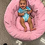 baby, smiling, blue_onesie, pink_chair, cushion, floor, tile_floor, indoor, child, happy, person, seat, plush, clothing, infant, cute, baby_face, furniture, relaxing, young_child