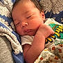 Sebastian is registered to the contest to win money with this photo: baby, newborn, sleeping, blanket, floral_pattern, blue, white_clothing, infant, peaceful, closeup, skin, face, hand, cute, resting, soft, indoors, portrait, child, cozy