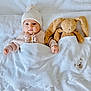 adorable, baby, bed, blanket, bunny, child, comfort, cute, indoor, infant, knit_hat, peaceful, plush_toy, resting, sleepwear, soft_texture, sweater, toy, tucked_in, warm