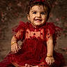 baby, barefoot, blurred_background, bow, bracelet, child, earrings, fashion, happy, headband, infant, jewelry, photography, polka_dots, portrait, red_dress, sitting, smiling, studio, tulle