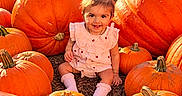 Adhya is registered to the contest to win money with this photo: autumn, baby, boots, child, fall, farm, harvest, nature, orange, outdoor, pigtails, pink_dress, portrait, pumpkin, pumpkin_patch, seasonal, sitting, smiling, sunlight, toddler