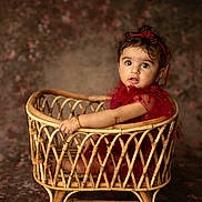 Adhya joined the competition — help win amazing prizes! baby, child, portrait, sitting, wicker_bassinet, basket, red_dress, headband, bow, curly_hair, wide_eyes, facial_expression, indoor, studio, vintage, furniture, rattan, warm_lighting, textile_background, photography