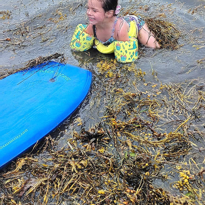 Portia is registered to the contest to win money with this photo: beach, child, clothing, coast, face, female, girl, head, lifejacket, nature, outdoors, person, photography, portrait, sea, seawaves, shoreline, swimwear, vest, water