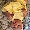 Aamiri is registered to the contest to win money with this photo: baby, infant, child, portrait, upside_down, yellow_outfit, floral_clothing, pink_headband, flower, blanket, lying_down, indoor, closeup, face, eyes, hands, feet, barefoot, smiling, cozy