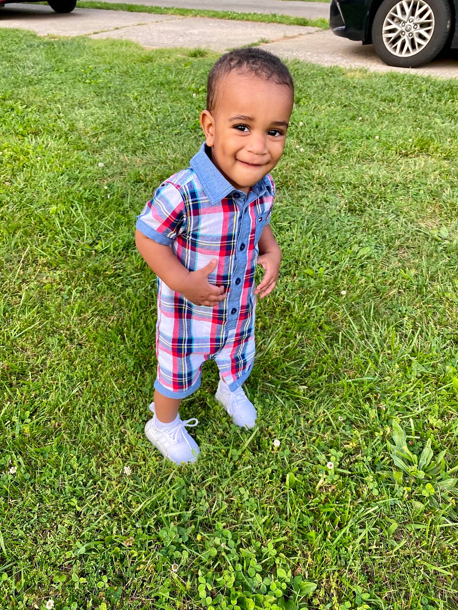 Emir is registered to the contest to win money with this photo: automotive_tire, child, eye, flooring, grass, grass_family, grassland, green, groundcover, happy, joy, lawn, mammal, people_in_nature, person, plaid, plant, smile, tartan, tire