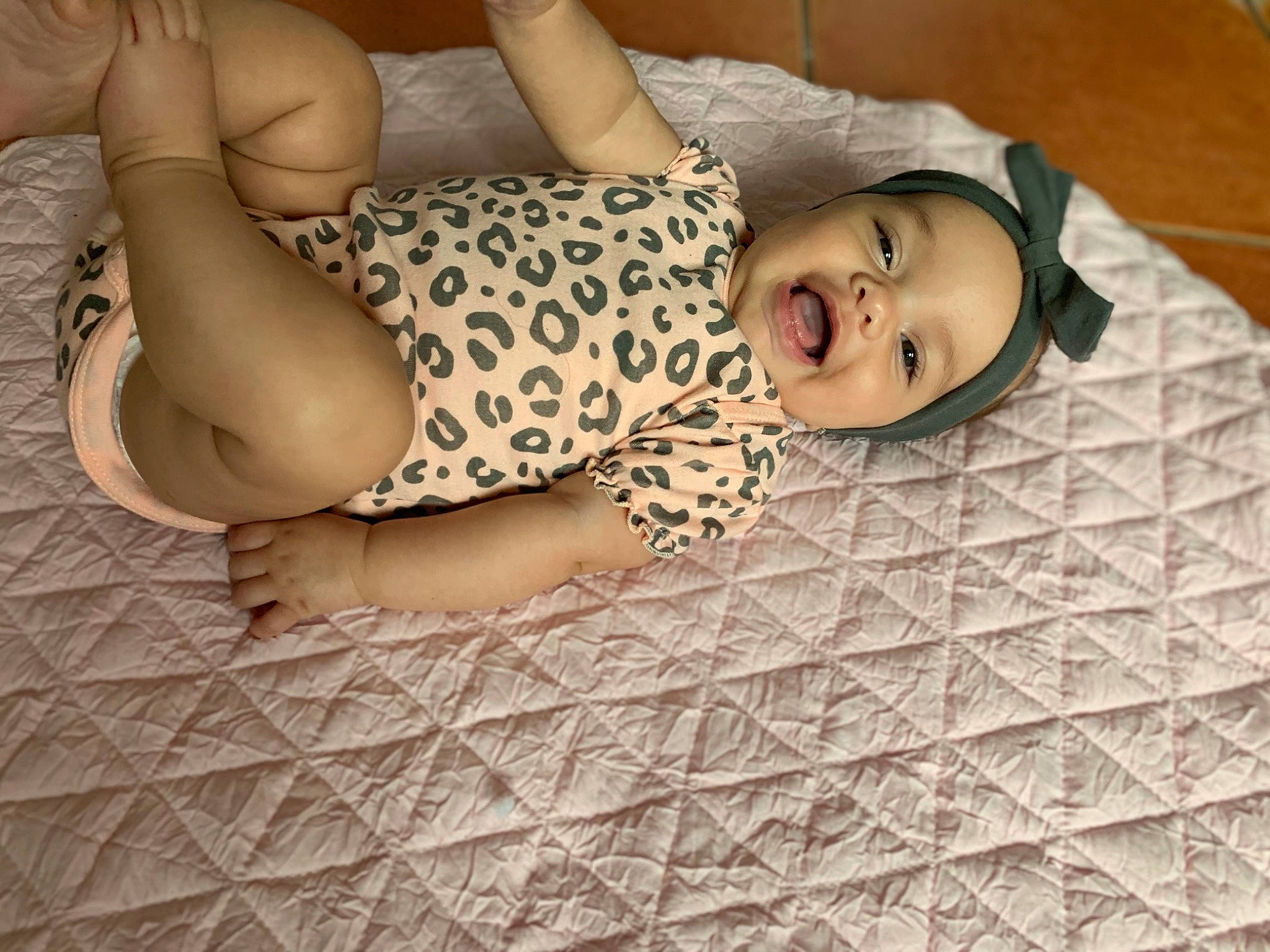 Giuliana joined the competition — help win amazing prizes! bed, bed_sheet, bedding, bedroom, child, comfort, elbow, floor, flooring, fun, hardwood, headwear, human_leg, knee, linens, pattern, person, smile, textile, thigh