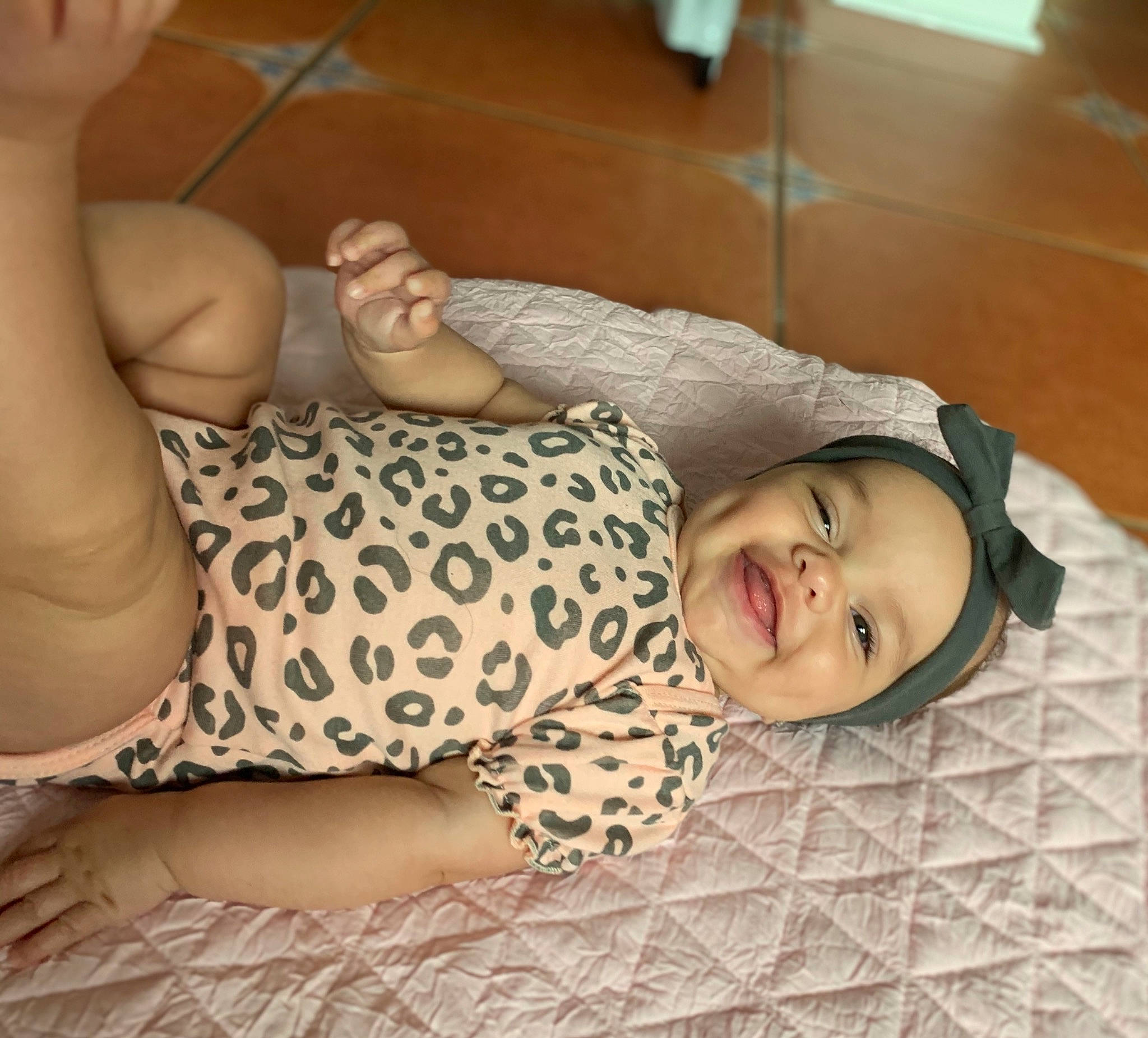 Giuliana is registered to the contest to win money with this photo: arm, chest, child, comfort, elbow, finger, flooring, hand, happy, headwear, human_leg, knee, linens, people, person, skin, sleeve, smile, thigh, thumb