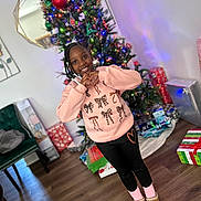 A'Mari joined the competition — help win amazing prizes! child, girl, christmas_tree, holiday, presents, indoors, smiling, heart_hands, sweatshirt, leggings, slippers, socks, wooden_floor, mirror, chair, decorations, lights, festive, happy, home