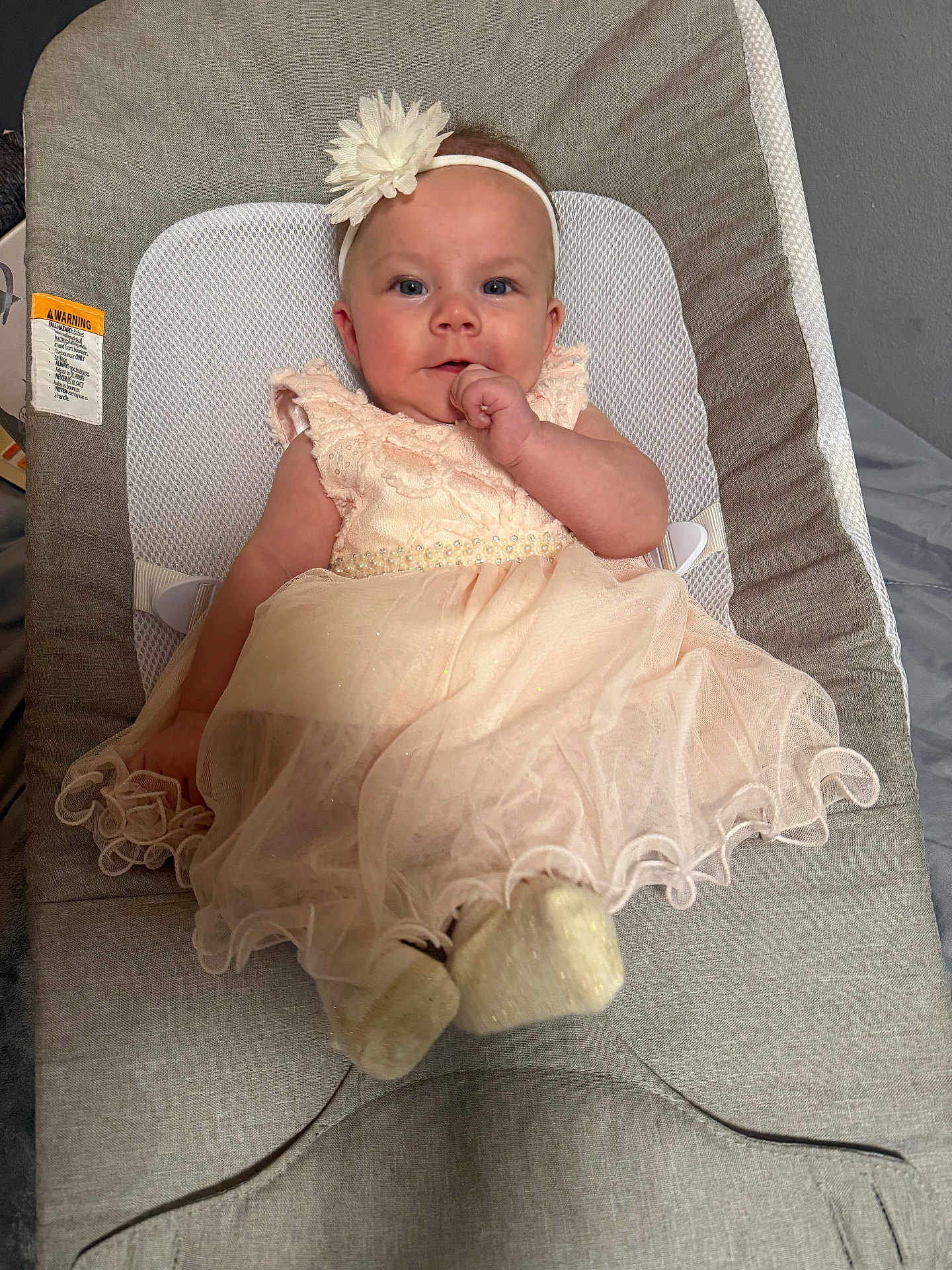 Mila is registered to the contest to win money with this photo: baby, infant, child, dress, headband, flower, seated, baby_seat, cushion, indoor, cute, portrait, soft_lighting, clothing, footwear, hand, face, smile, blue_eyes, curious