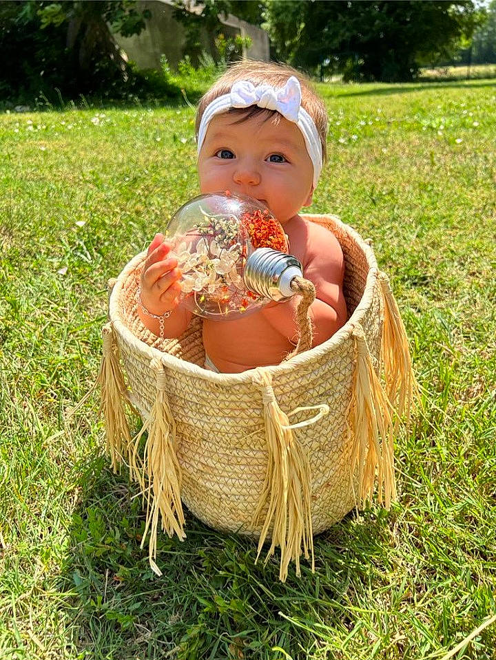 Fabiana a rejoint le concours — aidez-le/la à gagner de superbes lots ! baby, baby_toddler_clothing, basket, child, event, fruit, grass, grass_family, grassland, happy, headwear, home_accessories, lawn, natural_foods, people_in_nature, person, plant, recreation, sitting, storage_basket