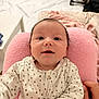 Côme participe au concours pour gagner de l'argent avec cette photo : baby, infant, child, pink_cushion, white_outfit, polka_dots, smiling, hand, face, eyes, indoor, soft_texture, cute, person, newborn, cozy, warm, comfortable, home, portrait