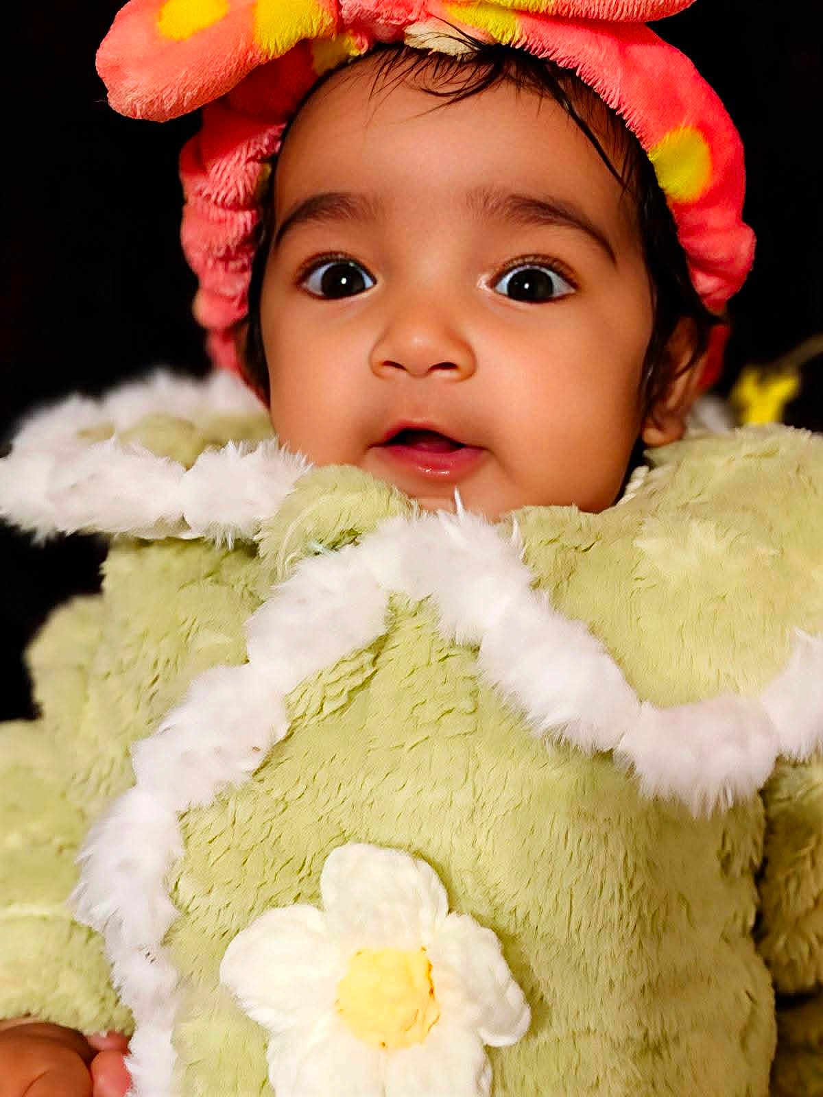 Anshika joined the competition — help win amazing prizes! baby, child, face, portrait, costume, hat, flower, fuzzy_clothing, cute, wide_eyes, infant, soft_texture, adorable, closeup, expression, young_child, colorful, warm_clothing, innocence, curious