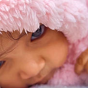 Anshika is registered to the contest to win money with this photo: child, face, close_up, blanket, pink, soft_texture, hand, eye, curious, cozy, sleepy, cute, baby, portrait, warm, tender, skin, fuzzy, resting, indoor
