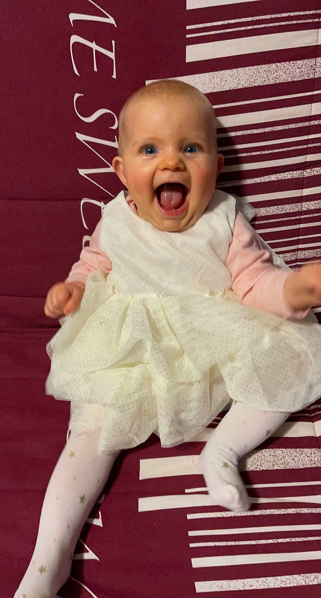 Alice a rejoint le concours — aidez-le/la à gagner de superbes lots ! baby, baby_toddler_clothing, cheek, child, dress, eye, facial_expression, gesture, happy, head, iris, linens, neck, pattern, person, pink, skin, sleeve, smile, textile