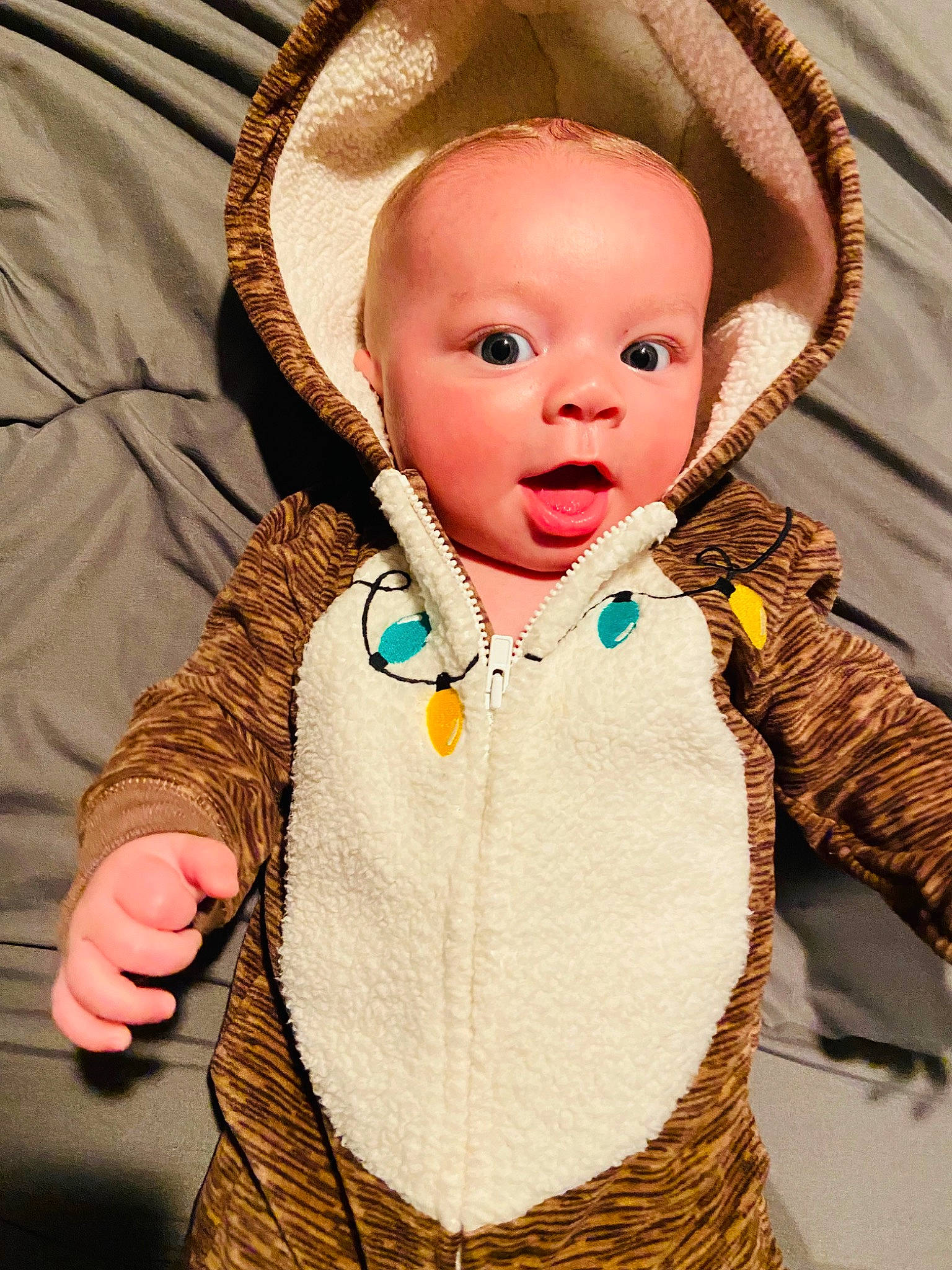 Keaton is registered to the contest to win money with this photo: baby, baby_toddler_clothing, cheek, child, doll, eye, fashion_accessory, finger, happy, human_body, nose, organ, people, person, skin, sleeve, surprise, textile, toddler, wood