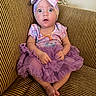 Jayla joined the competition — help win amazing prizes! baby, child, clothing, couch, cute, dress, expression, furniture, headband, indoors, infant, person, portrait, purple, sitting, smile, striped_couch, surprised, tutu, wide_eyes