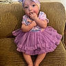 baby, child, girl, purple_dress, headband, sitting, couch, striped_couch, indoor, barefoot, cute, portrait, infant, smiling, hands, feet, clothing, person, toddler, happy