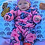 Rose is registered to the contest to win money with this photo: baby, infant, pink_onesie, headband, purple_headband, orange_socks, jack_o_lantern, elephant_pattern, pillow, autumn_leaves, outdoor, grass, cute, smiling, cozy, child, young_baby, fuzzy_clothing, happy, relaxed