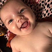 Kallie joined the competition — help win amazing prizes! baby, smile, face, infant, skin, blanket, pattern, leopard_print, floral_print, happy, closeup, child, portrait, lying_down, cute, young, cheerful, indoors, soft_texture, warm