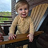 Zeke joined the competition — help win amazing prizes! toddler, child, baby, polka_dot, onesie, wooden_chair, porch, smile, blue_eyes, hand, wood, outdoor, railing, cabin, nature, greenery, sky, happy, person, face