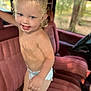 toddler, child, diaper, smiling, blonde_hair, blue_eyes, vehicle_interior, red_seat, messy_face, curly_hair, standing, young_child, car_seat, window, indoor, happy, person, cute, portrait, baby