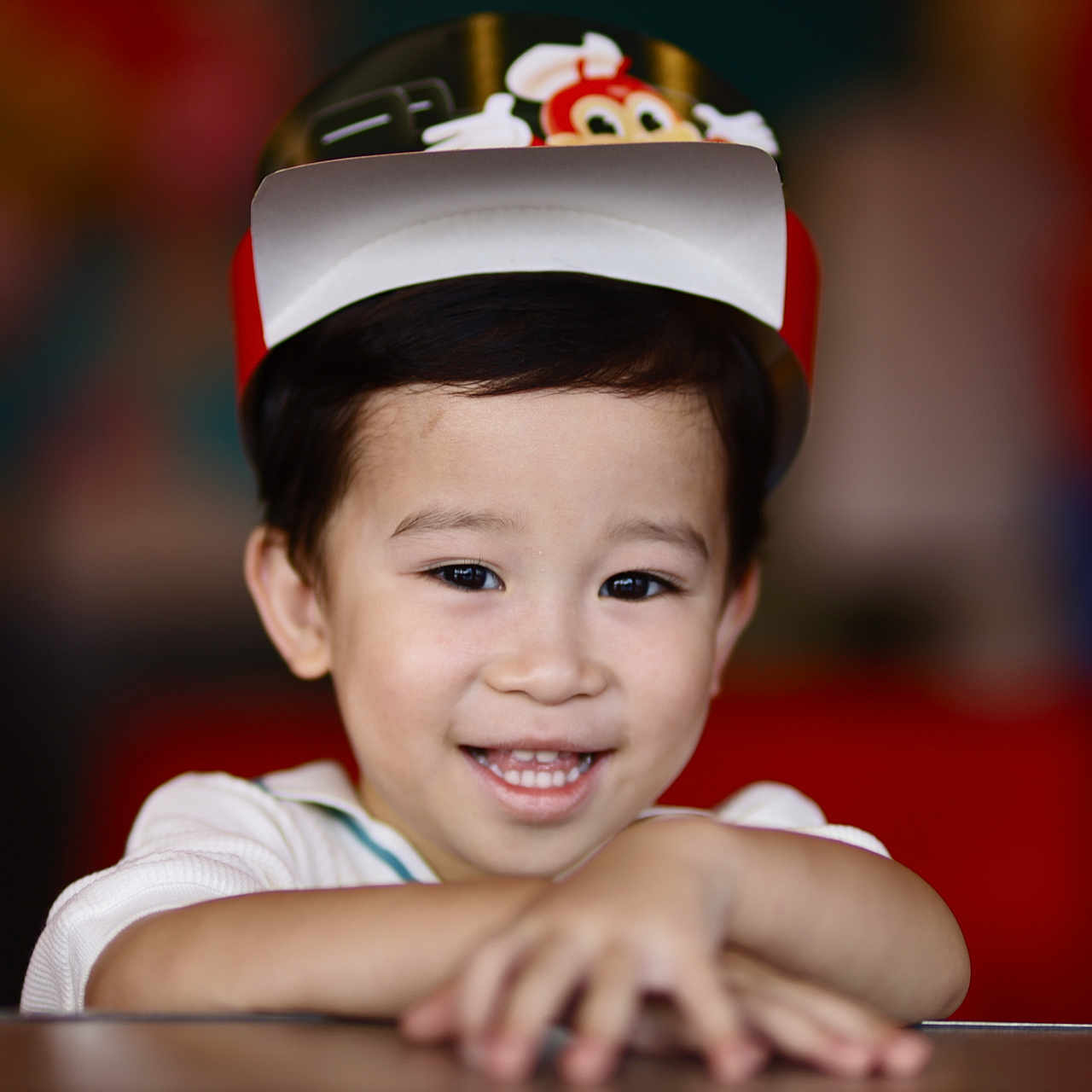Paris joined the competition — help win amazing prizes! child, smiling, hat, face, hands, portrait, indoor, happy, young_child, cartoon_character, colorful, cute, person, casual_clothing, closeup, headwear, dark_hair, skin, expression, blurred_background
