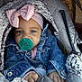 baby, infant, pacifier, denim_jacket, pink_bow, headband, car_seat, blanket, cozy, child, clothing, cute, portrait, indoor, hands, face, blue_eyes, warm, soft_texture, closeup