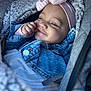 baby, child, face, smile, headband, bow, denim_jacket, blanket, car_seat, cozy, cute, portrait, infant, clothing, happy, closeup, warm, soft_light, resting, person