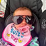Jensyn is registered to the contest to win money with this photo: baby, sunglasses, pacifier, bib, car_seat, clothing, infant, face, pink, purple, green, pattern, rainbow, heart, closeup, child, cute, safety_label, seat, portrait