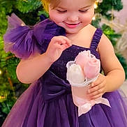 Luna a rejoint le concours — aidez-le/la à gagner de superbes lots ! bouquet, bow, celebration, child, christmas_tree, cute, dress, festive, flowers, girl, greenery, hair_clip, happy, holiday, indoor, portrait, purple_dress, smiling, toddler, young_child