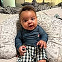 Julian joined the competition — help win amazing prizes! baby, child, infant, pillow, animal_print, pattern, clothing, shorts, long_sleeve_shirt, bedroom, curtains, bed, plaid, cute, sitting, indoors, person, young_child, expression, comfort