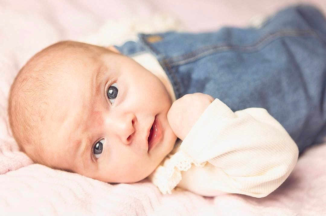 Yazmin is registered to the contest to win money with this photo: baby, infant, face, eyes, skin, clothing, denim, overalls, blanket, soft, cute, portrait, newborn, child, laying, expression, hand, closeup, indoor, person