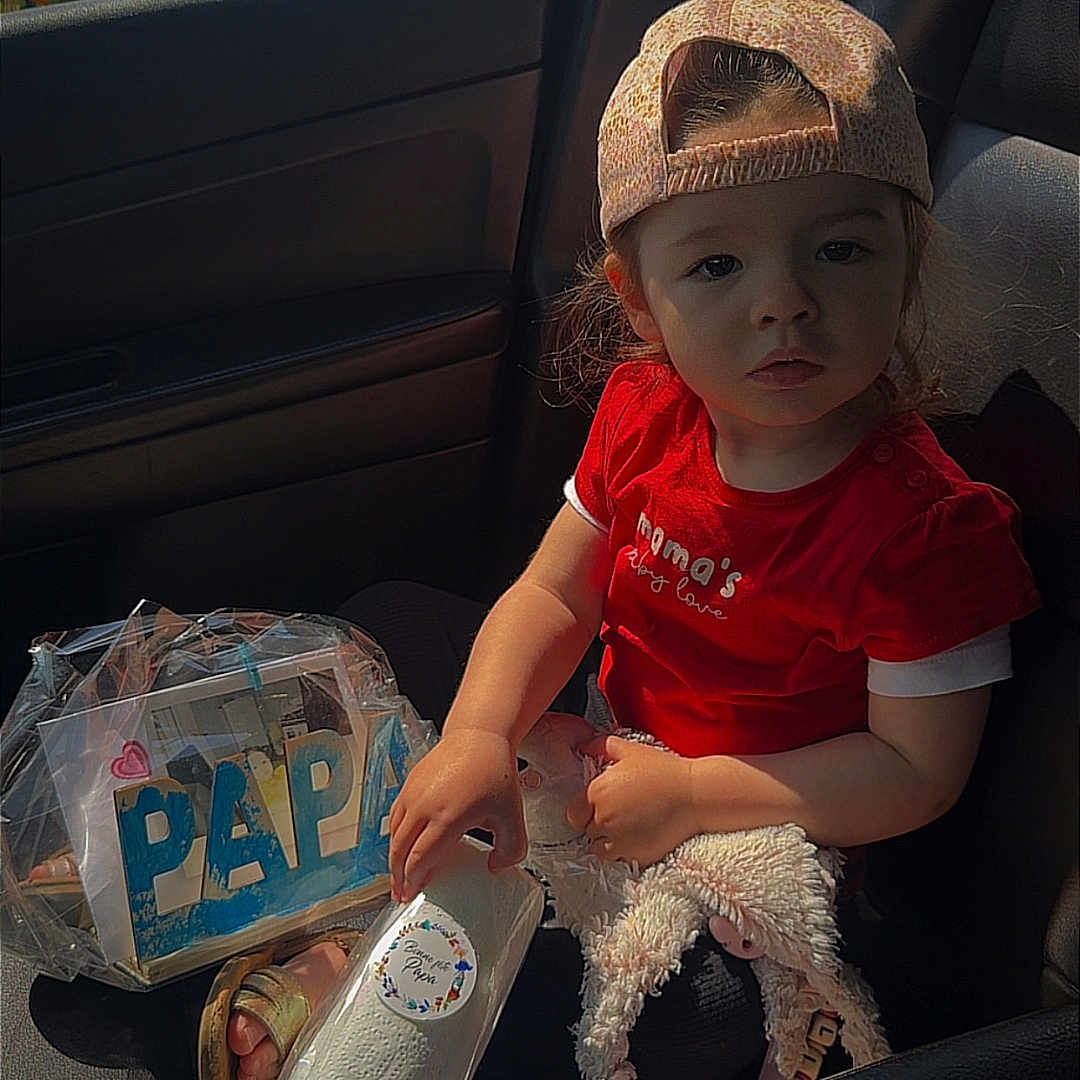 Kellyana a rejoint le concours — aidez-le/la à gagner de superbes lots ! automobile, backwards_cap, car_interior, child, curious_expression, footwear, hand, indoor, package, plastic_wrap, portrait, red_shirt, seat, seatbelt, stuffed_animal, sunlight, toddler, toy, window, wrapped_gift
