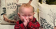Ashton is registered to the contest to win money with this photo: baby, black_pants, child, christmas_tree, clapping, cozy, cute, decorations, festive, green, happy, holiday_decor, indoor, infant, lights, pillows, plaid_shirt, red, sitting, smiling