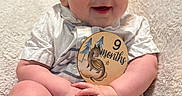 Ashton joined the competition — help win amazing prizes! baby, infant, child, smiling, milestone, sign, dragon, clothing, striped, shorts, shirt, blanket, soft, cute, happy, portrait, sitting, hands, legs, indoors