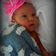 Ashlynn is registered to the contest to win money with this photo: baby, infant, blanket, pink_flower, headband, face, wrapped, cozy, soft_texture, newborn, cute, lying_down, portrait, closeup, child, sleepwear, warm, indoor, skin, expression