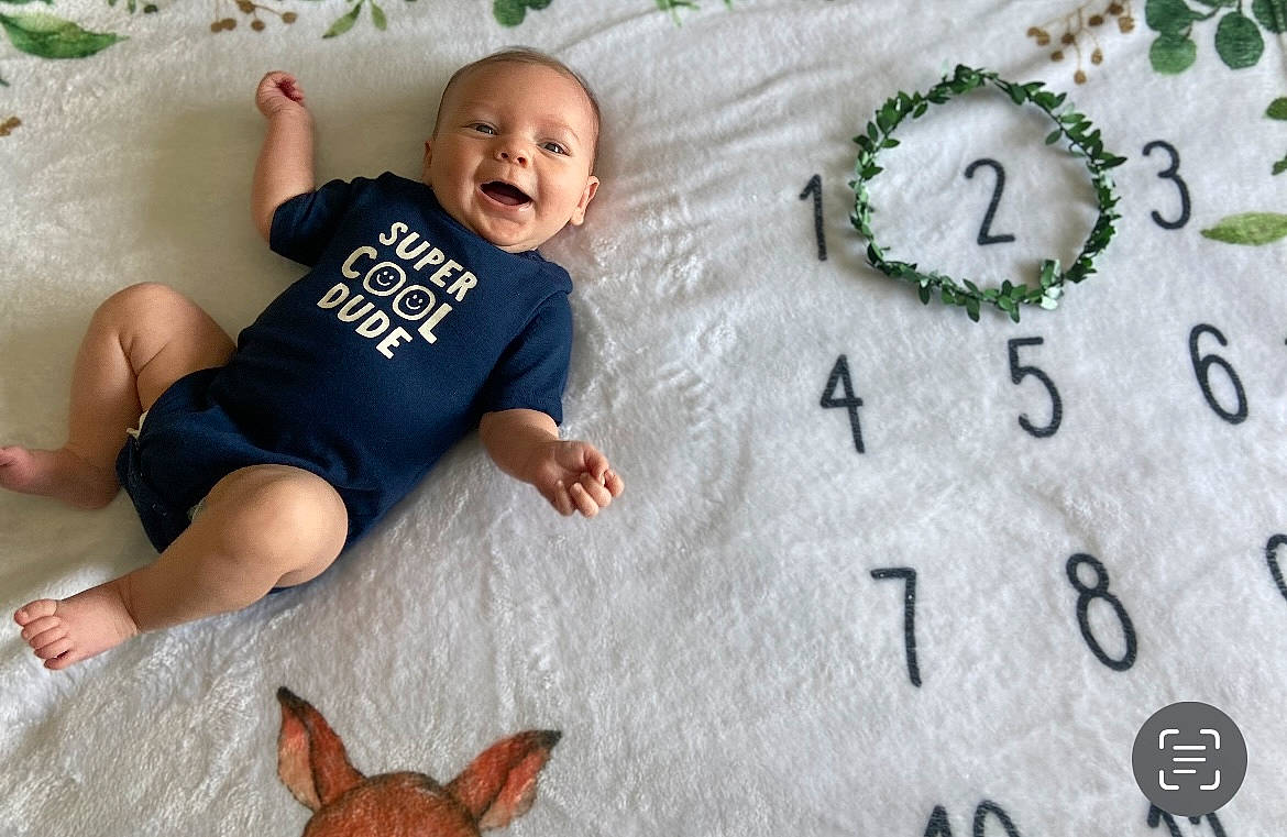 Kane is registered to the contest to win money with this photo: baby, baby_toddler_clothing, barefoot, child, circle, comfort, flooring, foot, fun, grass, happy, human_leg, leisure, pattern, person, photograph, smile, t_shirt, toddler, tree