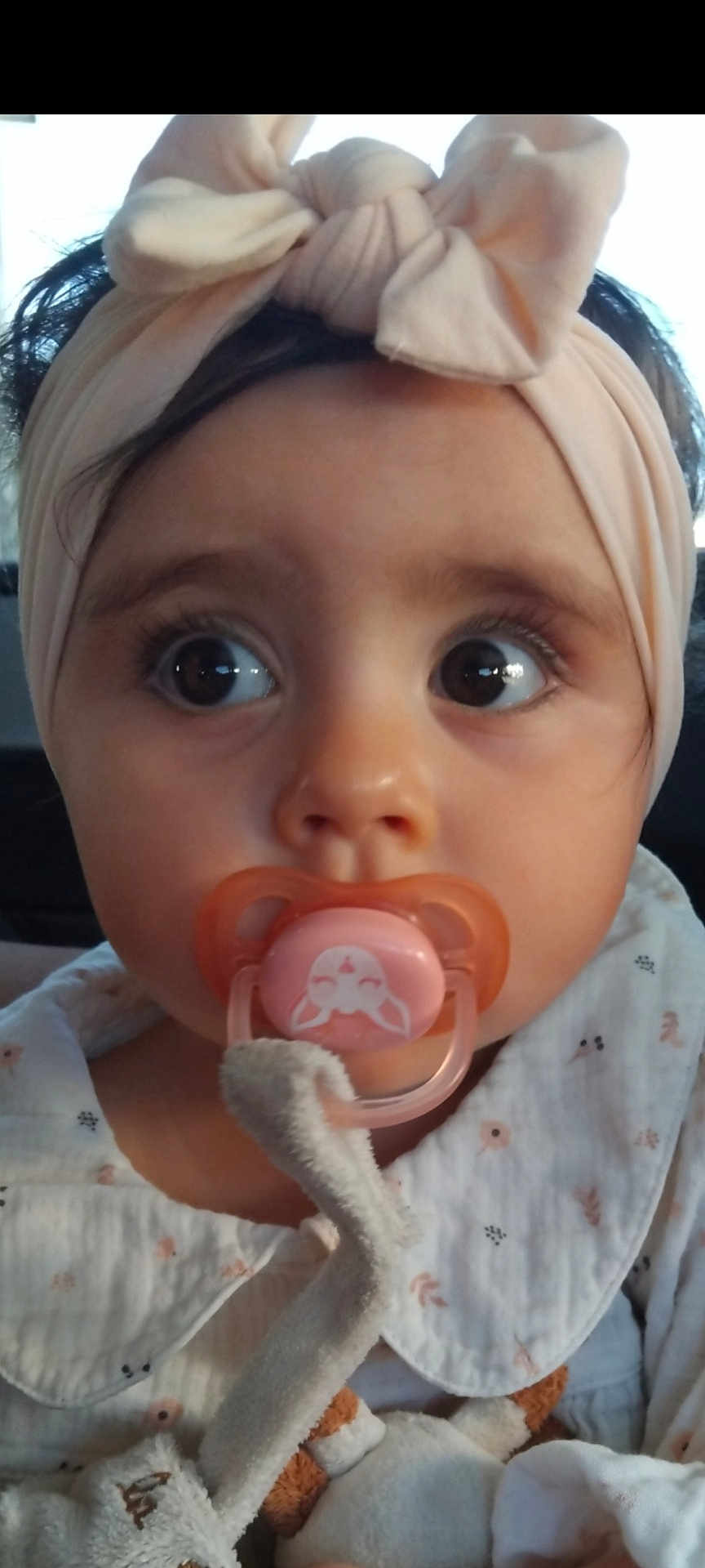 Lana participe au concours pour gagner de l'argent avec cette photo : baby, pacifier, headband, bow, close_up, infant, cute, child, plush_toy, clothing, white_outfit, curious_eyes, face, person, soft_light, indoors, portrait, young_child, adorable, expression