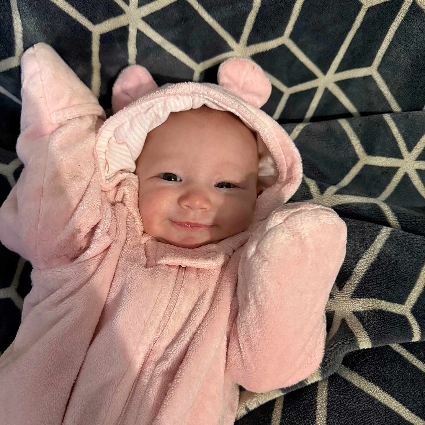 Haleigh Rose joined the competition — help win amazing prizes! apparel, baby, blanket, child, cozy, cute, ears, face, geometric_pattern, happy, hood, indoor, infant, lying_down, pink_onesie, portrait, smile, soft_texture, warm_clothing, young_child