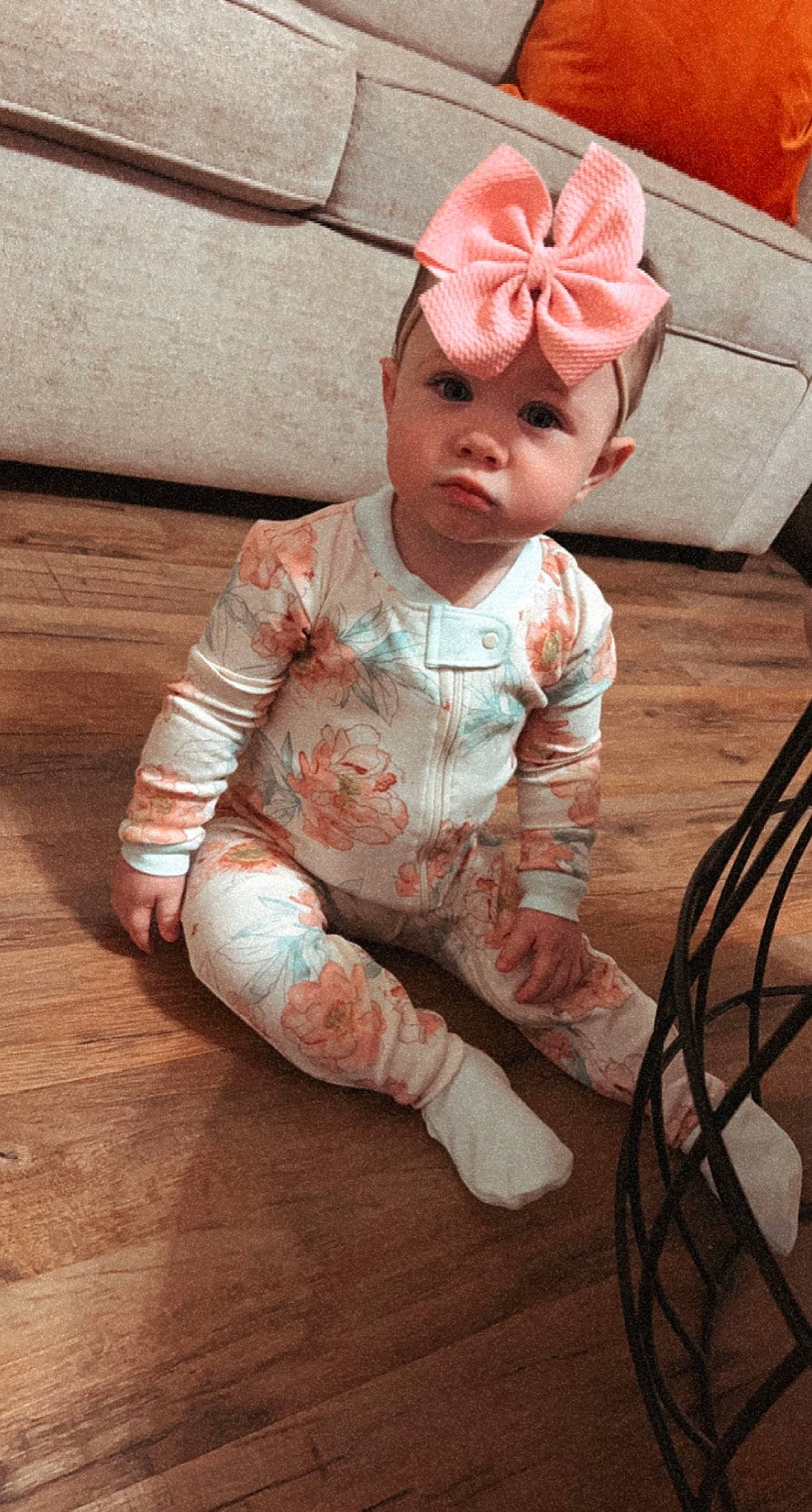 Remi is registered to the contest to win money with this photo: baby, baby_toddler_clothing, carmine, cheek, child, fashion_accessory, floor, flooring, foot, fun, happy, hardwood, head, headgear, headwear, peach, person, sitting, skin, sleeve