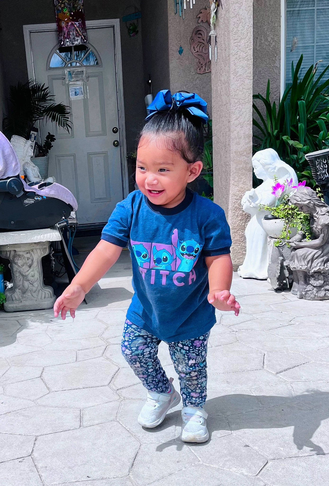 Jocelyn is registered to the contest to win money with this photo: baby_toddler_clothing, blue, child, electric_blue, event, flower, flowerpot, fun, happy, houseplant, leisure, person, plant, purple, recreation, shoe, sidewalk, sleeve, sneakers, standing