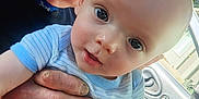 Jaxson is registered to the contest to win money with this photo: baby, child, adult, hand, car, vehicle_interior, window, person, face, skin, clothing, blue_shirt, striped_shirt, curious, holding, closeup, portrait, indoors, daylight, human