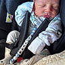 newborn, baby, sleeping, car_seat, infant, mittens, pacifier, pacifier_clip, clothing, child, face, person, seatbelt, soft_toy, blanket, indoor, cute, peaceful, tiny, resting