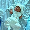 newborn, baby, sleeping, white_clothing, hat, mittens, blanket, blue_background, infant, cute, soft, cozy, resting, tiny, portrait, indoors, child, lying_down, warm, pom_poms