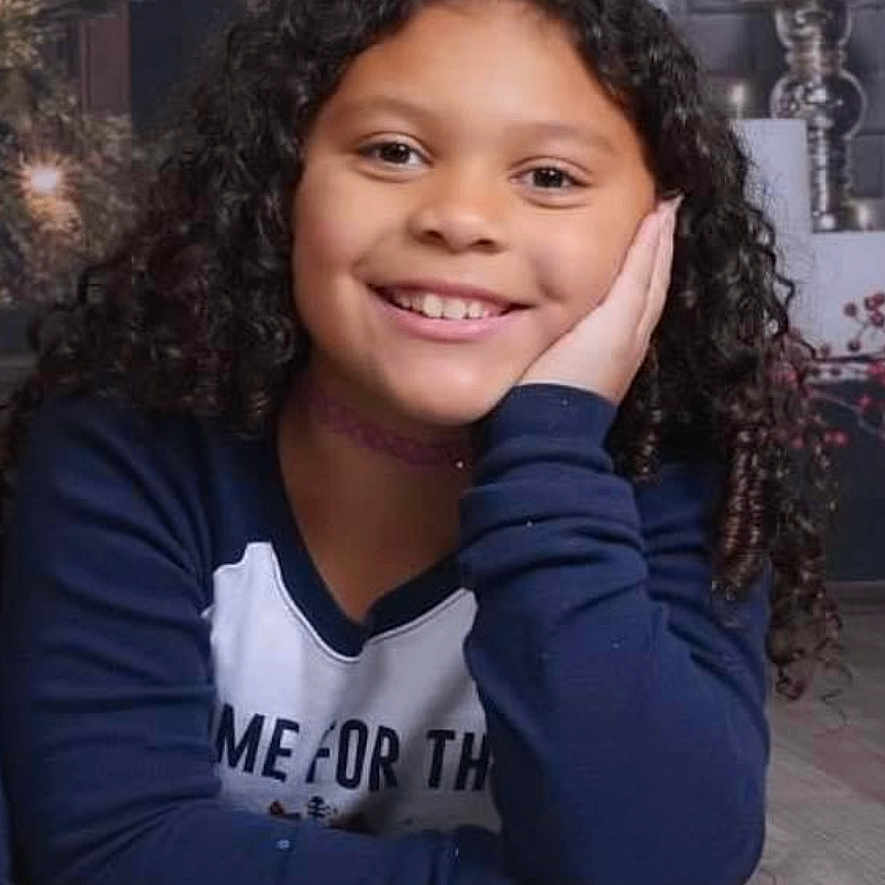 Sophia is registered to the contest to win money with this photo: blackhair, bodypart, child, dimples, face, female, finger, girl, hair, hand, happy, head, indoors, interiordesign, mouth, neck, person, photography, portrait, smile