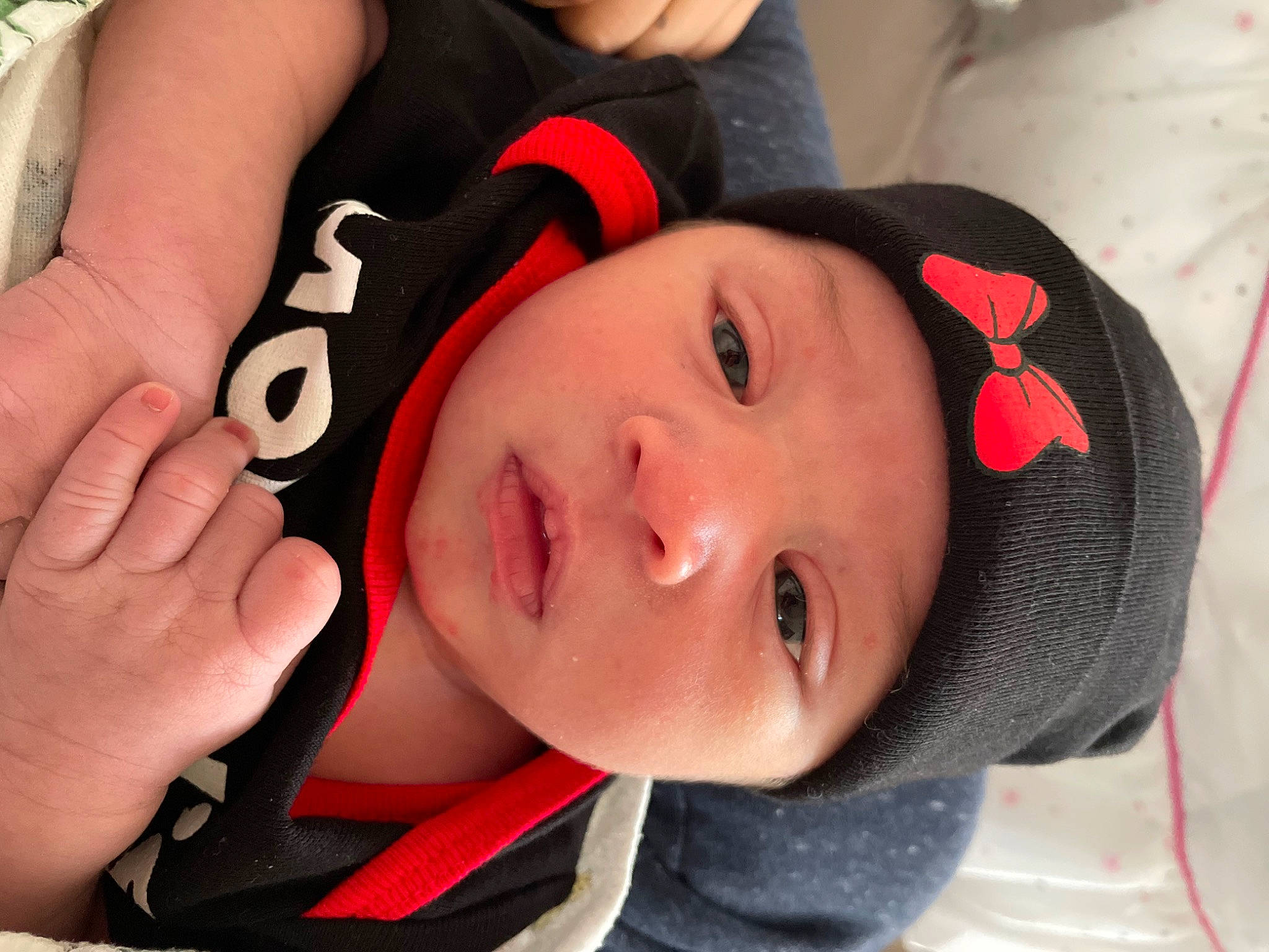 Anora is registered to the contest to win money with this photo: baby, cap, cheek, chin, comfort, ear, eye, eyebrow, eyelash, finger, gesture, hand, happy, headwear, lip, mammal, mouth, neck, nose, person
