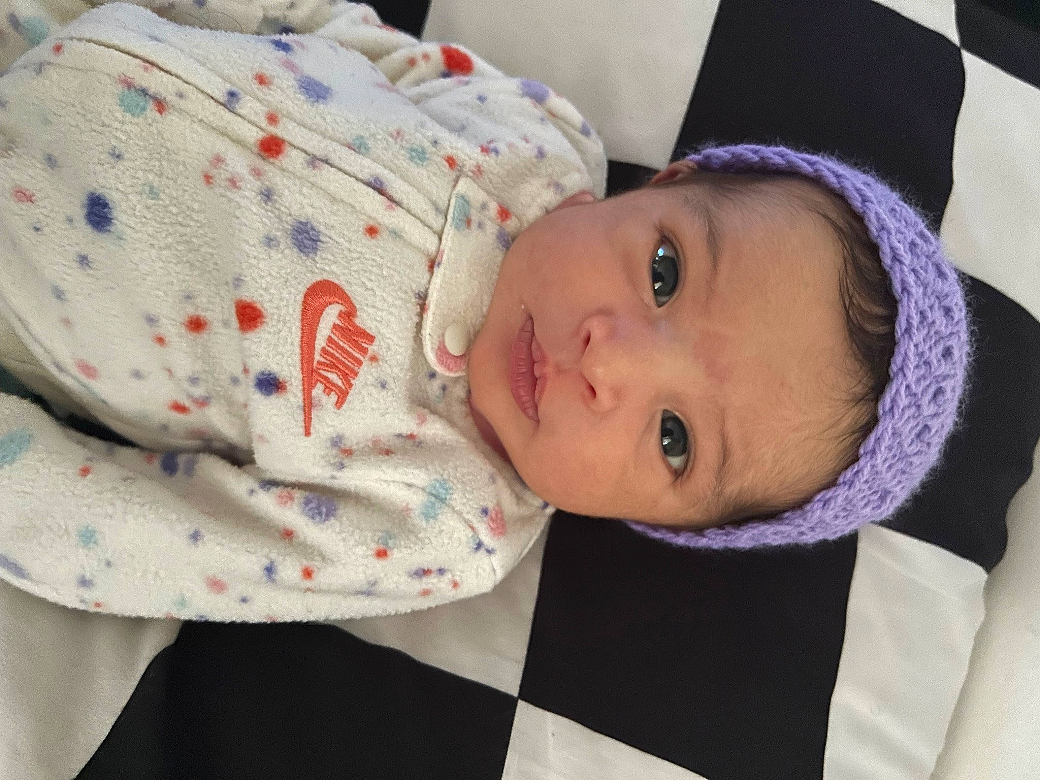 Celeste is registered to the contest to win money with this photo: baby, baby_products, baby_toddler_clothing, child, comfort, face, fashion_accessory, happy, hat, headgear, linens, lip, pattern, person, plaid, product, room, skin, sleeve, sun_hat